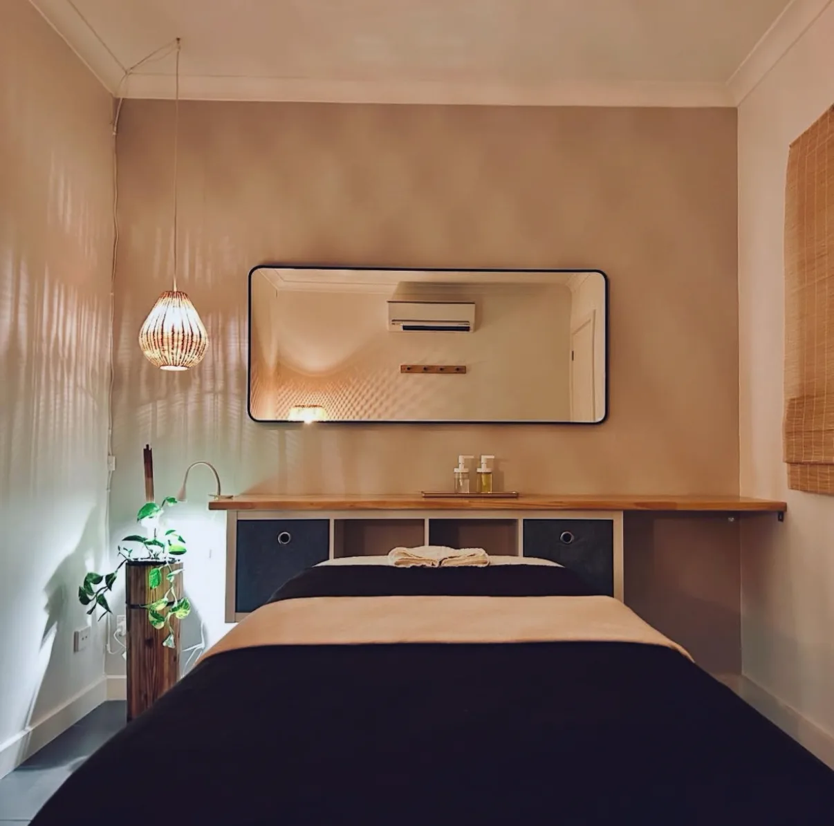 A Siam Ivory treatment room — dressed table, large mirror and rattan pendant lamp