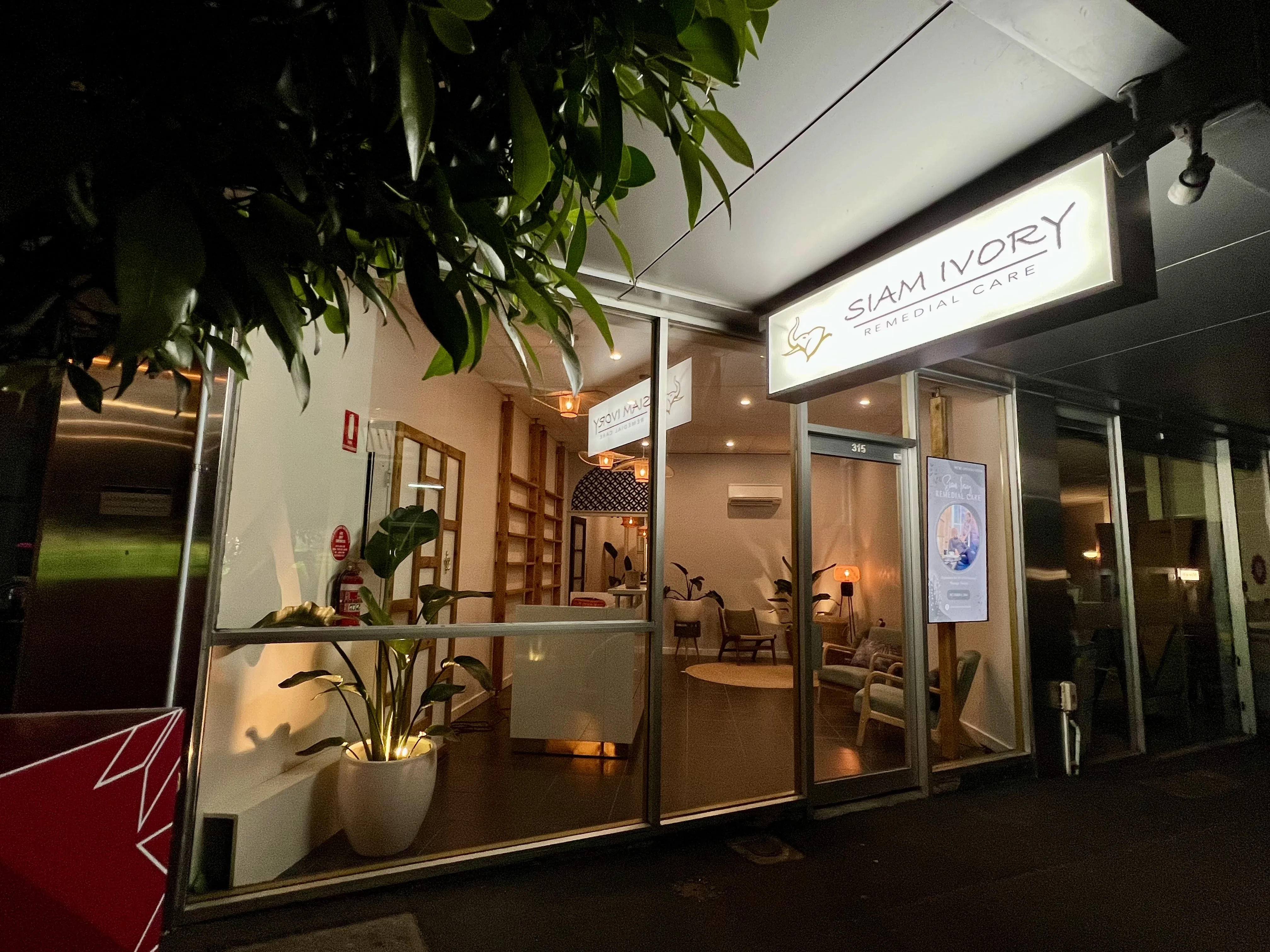 The illuminated Siam Ivory Remedial Care sign at 315 High Street Kew, at night