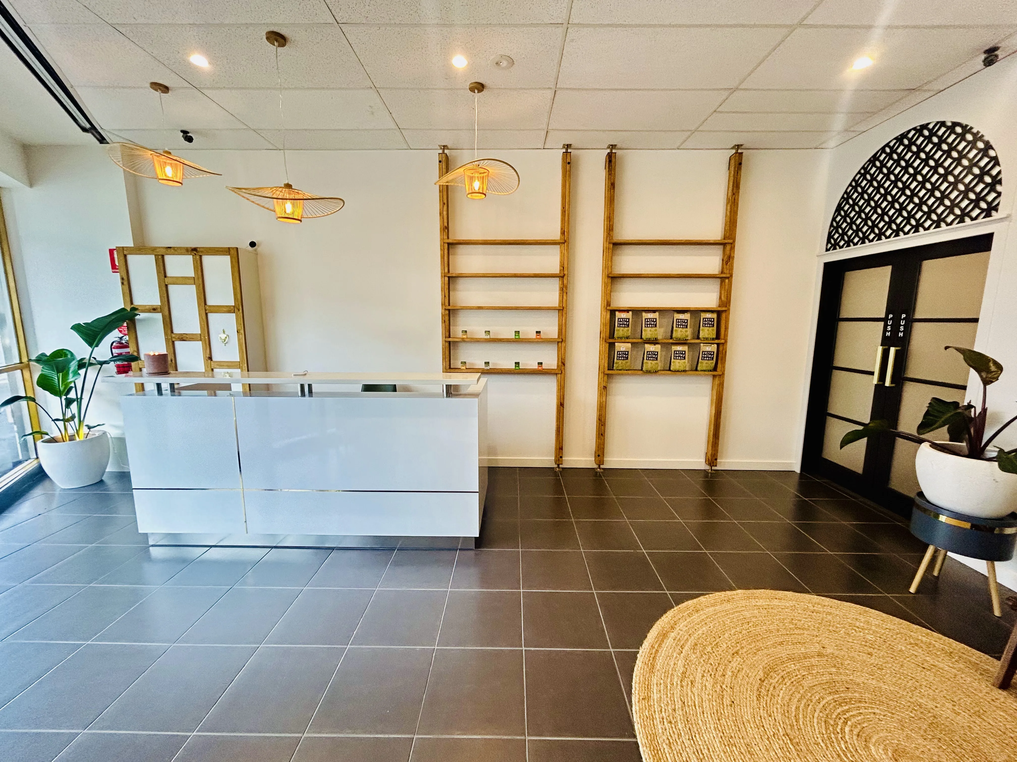Kew waiting room — arched lattice door, rattan lamp, jute rug and timber ladder shelf